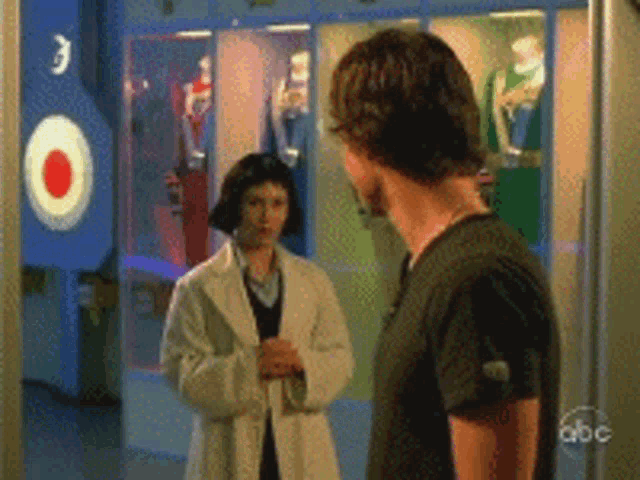 a man and a woman are standing next to each other in front of a sign that says 3
