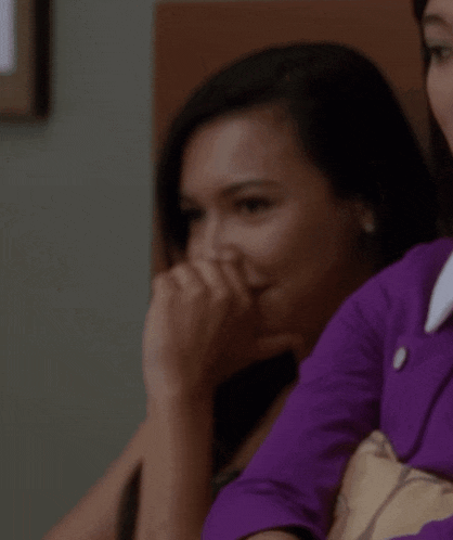 a woman in a purple jacket is covering her mouth