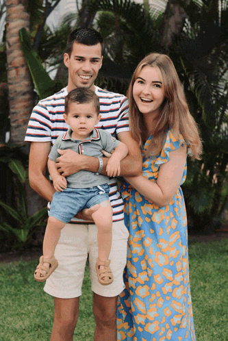 a man in a striped shirt is holding a baby boy