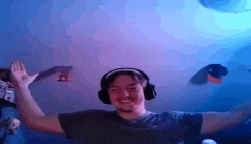 a man wearing headphones is dancing in a dark room .