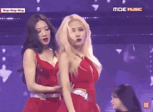 two women are dancing on a stage with the words mbc music on the bottom