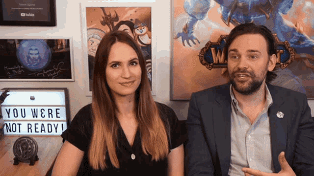 a man and a woman are standing next to a sign that says you were not ready