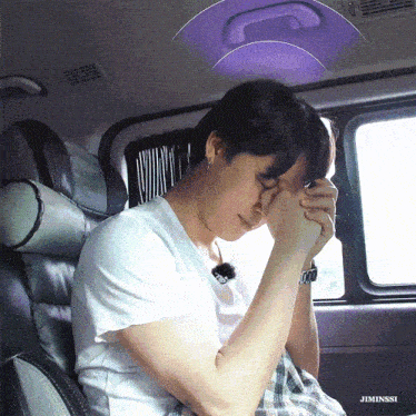 a man is sitting in the back seat of a car with his hands folded in prayer