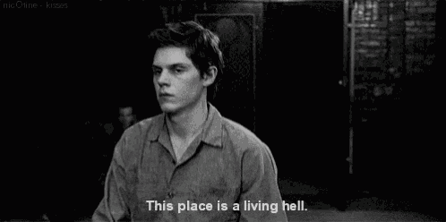 a black and white photo of a young man with a quote that says `` this place is a living hell '' .