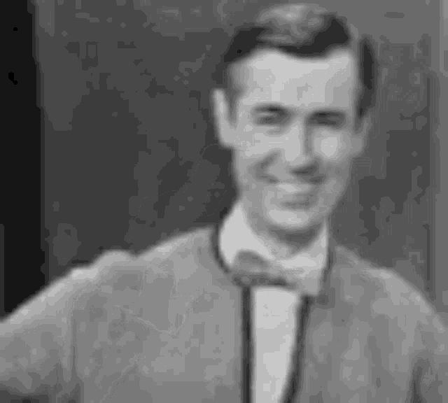 a black and white photo of a man in a suit and bow tie .