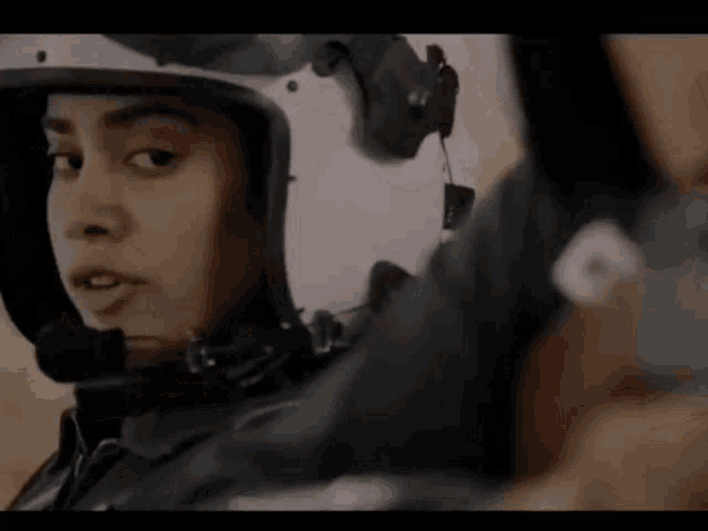 a close up of a woman wearing a helmet with headphones