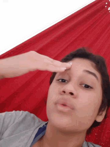 a woman laying down with her hand on her face