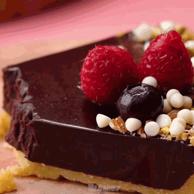 a piece of chocolate cake with raspberries and blueberries