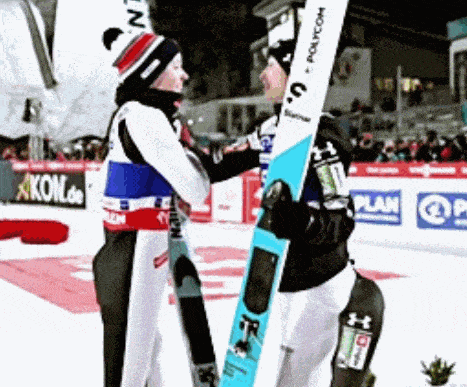 two skiers are hugging each other with one holding a ski that says polycom