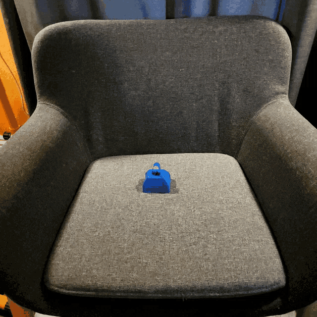 a gray chair with a blue cube on the seat