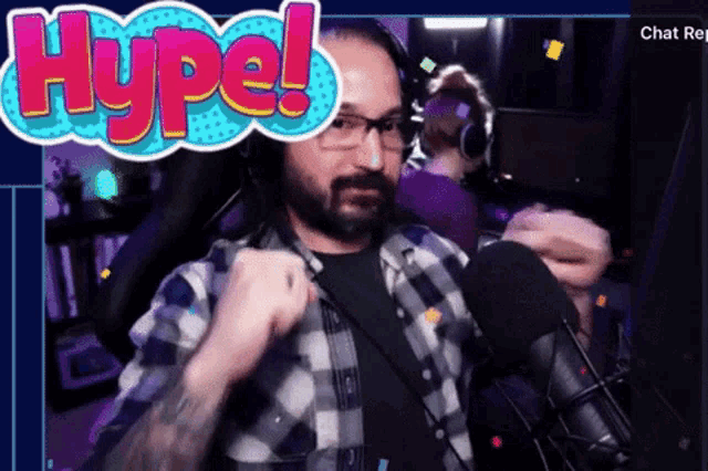 a man in a plaid shirt stands in front of a microphone with the words hype behind him