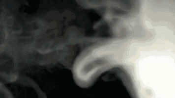 smoke is coming out of a pipe on a black background in slow motion .