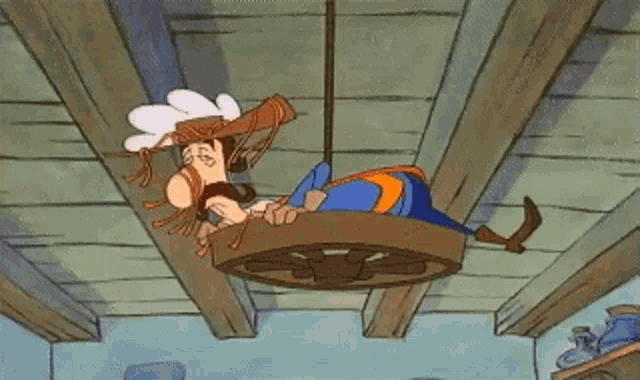 a cartoon character is laying on a wagon wheel hanging from the ceiling