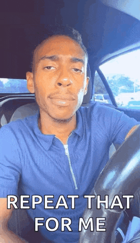 a man is sitting in the driver 's seat of a car with the words repeat that for me written on his face .