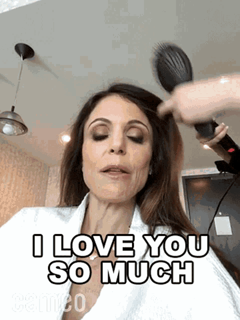 a woman in a bathrobe is getting her hair blow dried and says i love you so much