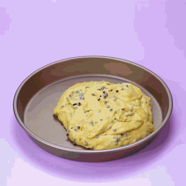 a pan filled with batter with chocolate chips and a green spatula