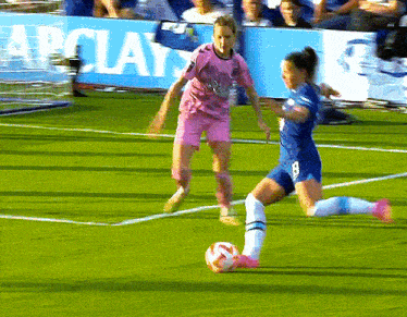 two female soccer players on a field with a banner that says barclays