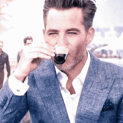 a man in a suit drinking from a glass