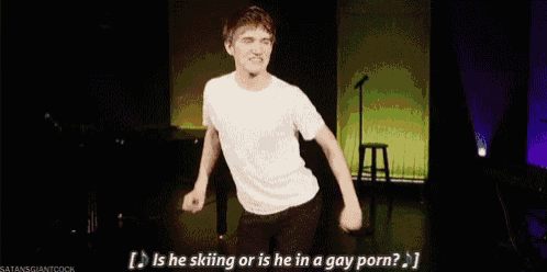 a man is standing on a stage holding a microphone and talking into it .
