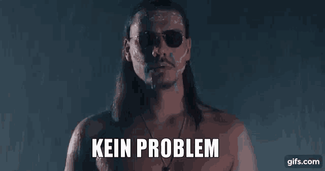 a shirtless man with long hair and sunglasses is standing in the rain with his face covered in paint and the words `` kein problem '' .