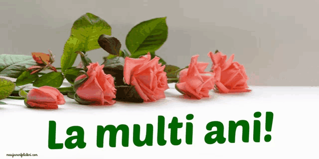 a bunch of pink roses with the words la multi ani in green