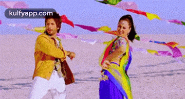 a man and a woman are dancing on a beach .