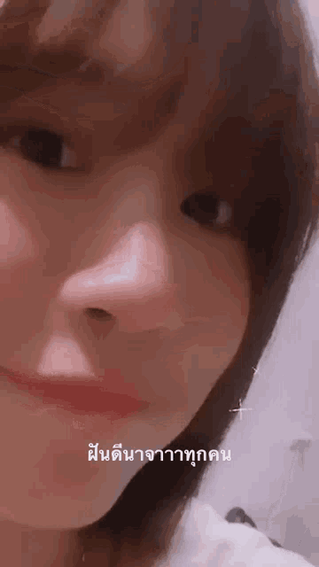 a close up of a woman 's face with foreign writing on the bottom