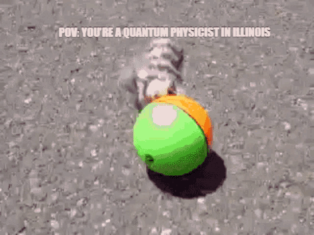 a skeleton is playing with a green and orange ball on the ground .