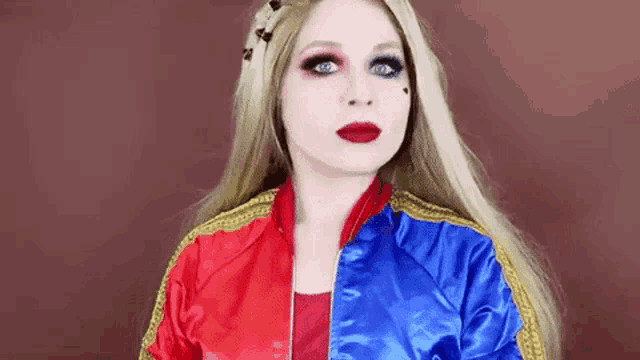 a woman in a harley quinn costume is looking at the camera .