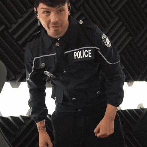 a man in a black police uniform is waving