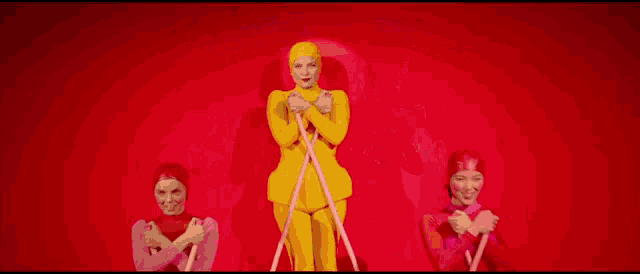 a group of people are standing next to each other on a red background .