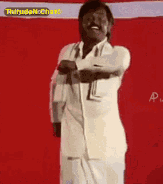 a man in a white shirt and tie is dancing in front of a red and white wall .