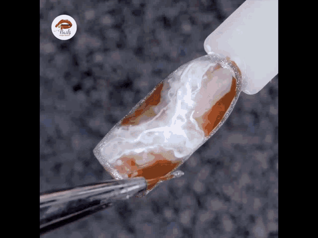 a close up of a nail with a bottle of nail polish in the background