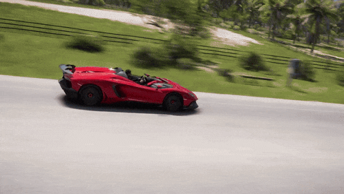 a red sports car driving down a road