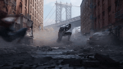 a man in a black suit is kneeling down in a city