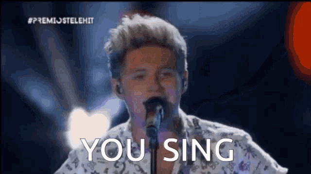 a man singing into a microphone with the words " you sing " above him