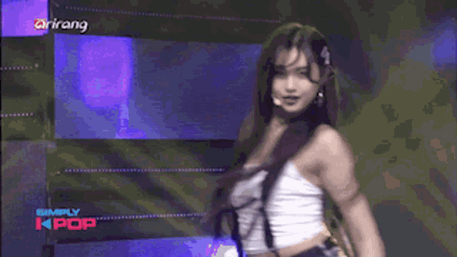 a woman is dancing on a stage with simply kpop written on the bottom