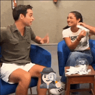 a man and a woman are sitting in chairs and talking