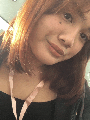 a woman with red hair and a lanyard around her neck