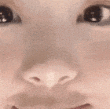 a close up of a woman 's face with a hand on her chin .
