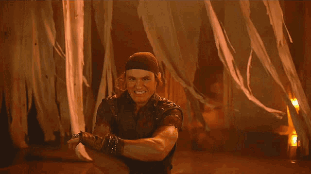 a man wearing a headband is holding a sword