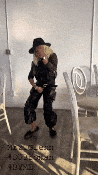 a woman in a hat is dancing in a room with chairs and the words mrz glenn #dubrotan #byme