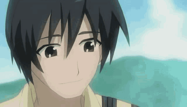 a close up of a boy 's face with a blue sky behind him