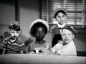 a group of young boys are sitting around a table in a room .