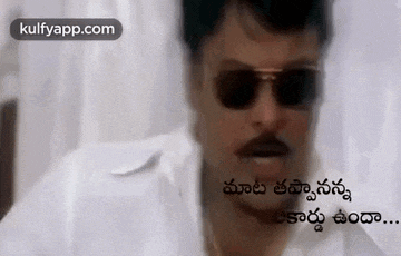 a man wearing sunglasses and a mustache is talking in a foreign language