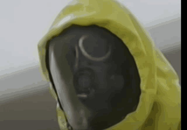 a person wearing a gas mask and a yellow jacket