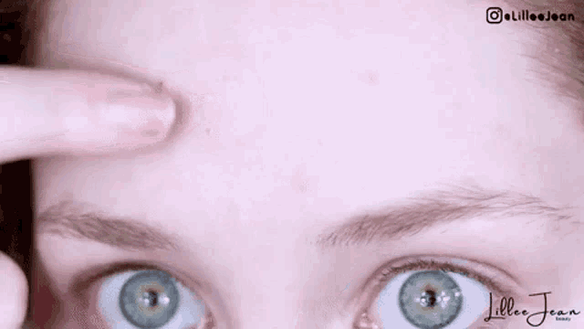 a close up of a person 's face with a finger pointing at their forehead .