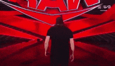a man in a black shirt is walking down a red aisle .