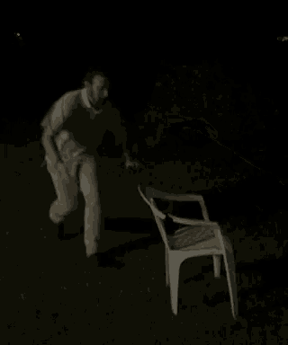 a blurry picture of a man holding a chair in his arms