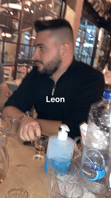 a man sitting at a table with the name leon written on it